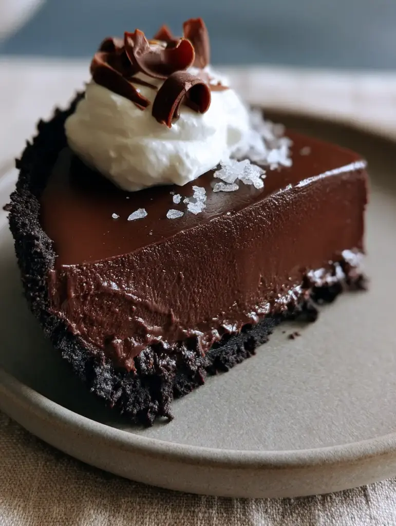 The Ultimate Ultra-Glossy Chocolate Pie Recipe: A Masterclass in Decadence 1 A single slice of chocolate pie being lifted from a matte plate, highlighting the dense filling and cloud-like whipped cream.