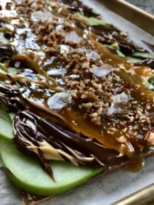 A handheld smartphone photo of Caramel Apple Bark in natural light on a high-end kitchen counter. (caramel apple bark)