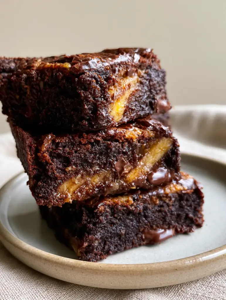 Banana Brownies: The Ultimate Fudgy Chocolate Banana Recipe 1 Macro shot of the shiny crackly top of a banana brownie with melting semi-sweet chocolate chunks.