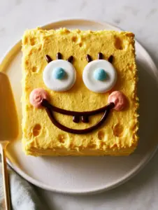 Close up of the lemon-yellow buttercream texture on a sponge bob patrick birthday cake.